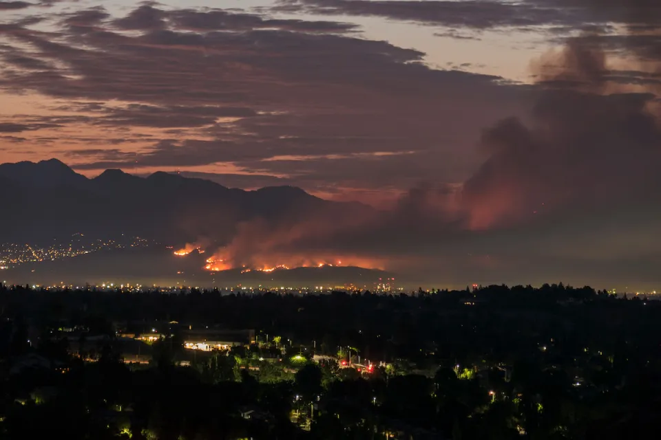 Nighttime view of wildfire in Los Angeles hills.